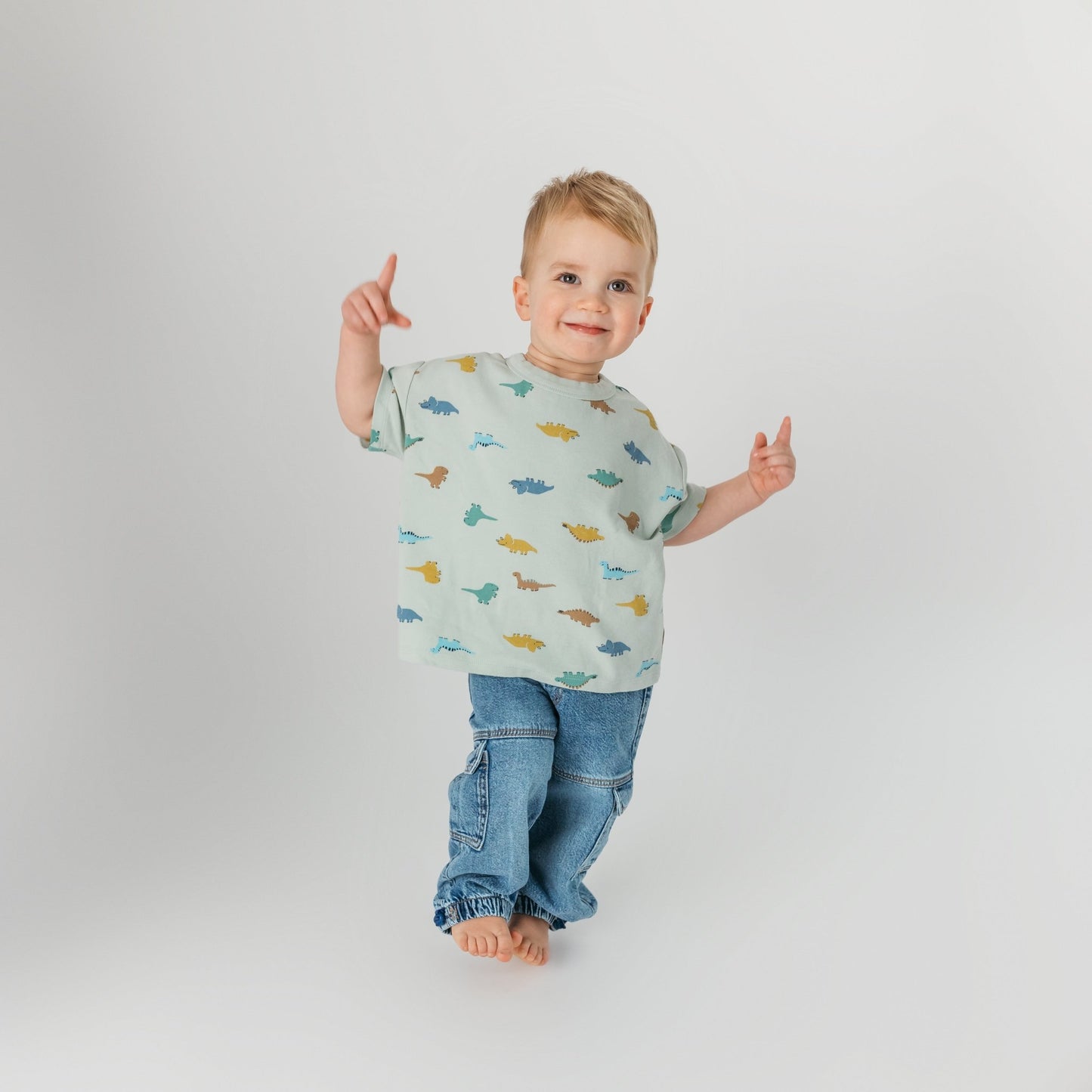 Child playing in comfortable mint dinosaur shirt - soft cotton kids clothing for active toddlers