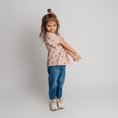 Child wearing pink daisy tee in loose comfortable fit - quality toddler tee