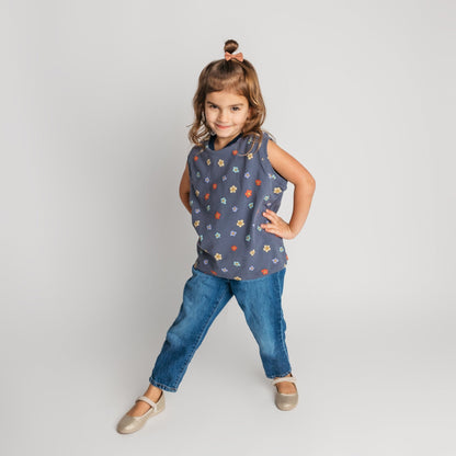 Child wearing blue daisy sleeveless shirt in loose comfortable fit - quality toddler tee